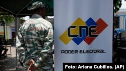 Un miembro de la milicia venezolana hace guardia cerca de un punto de registro y actualización de datos de votantes, en Caracas en 2024.