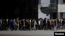 Agentes de civil, armados con palos, se dirigen a reprimir una protesta pacífica en La Habana, durante un apagón el 30 de septiembre de 2022.