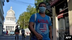 Un cubano luce la bandera de EEUU en su pulóver y usa tapabocas para protegerse del coronavirus.