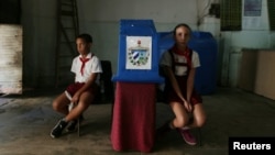 Dos niños custodian la urna en un colegio electoral de La Habana durante el referendo constitucional.