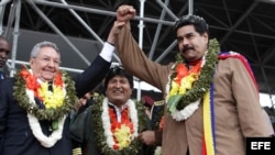 Evo Morales, Nicolás Maduro y Raúl Castro usan guirnaldas de hojas de coca en un encuentro en el estadio Tahuichi Aguilera.