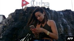 Una cubana chequea internet en su teléfono móvil en una calle de La Habana.