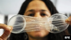 Una mujer muestra un condón femenino.