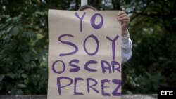 Una mujer sostiene un cartel en el que se lee "Yo soy Óscar Pérez" frente a la morgue donde permanece su cuerpo.