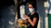 Una mujer con máscara protectora lleva el pan a casa, en La Habana. (Yamil Lage/AFP).