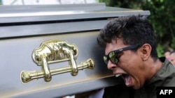 Un pariente de Gerald Velázquez, muerto a tiros durante enfrentamientos con la policía en una iglesia cerca de la Universidad Nacional Autónoma de Nicaragua, lleva el ataúd que contiene su cuerpo durante su funeral.