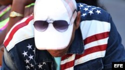 Un hombre usa una chaqueta con la bandera de estadounidense por una calle de La Habana.