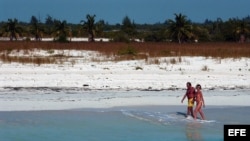 Una pareja de turistas camina por playa Sirena, en Cayo Largo del Sur.
