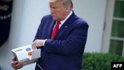 El presidente Donald Trump presenta el dispositivo de pruebas de COVID-19 de la firma Abbott, ID NOW.