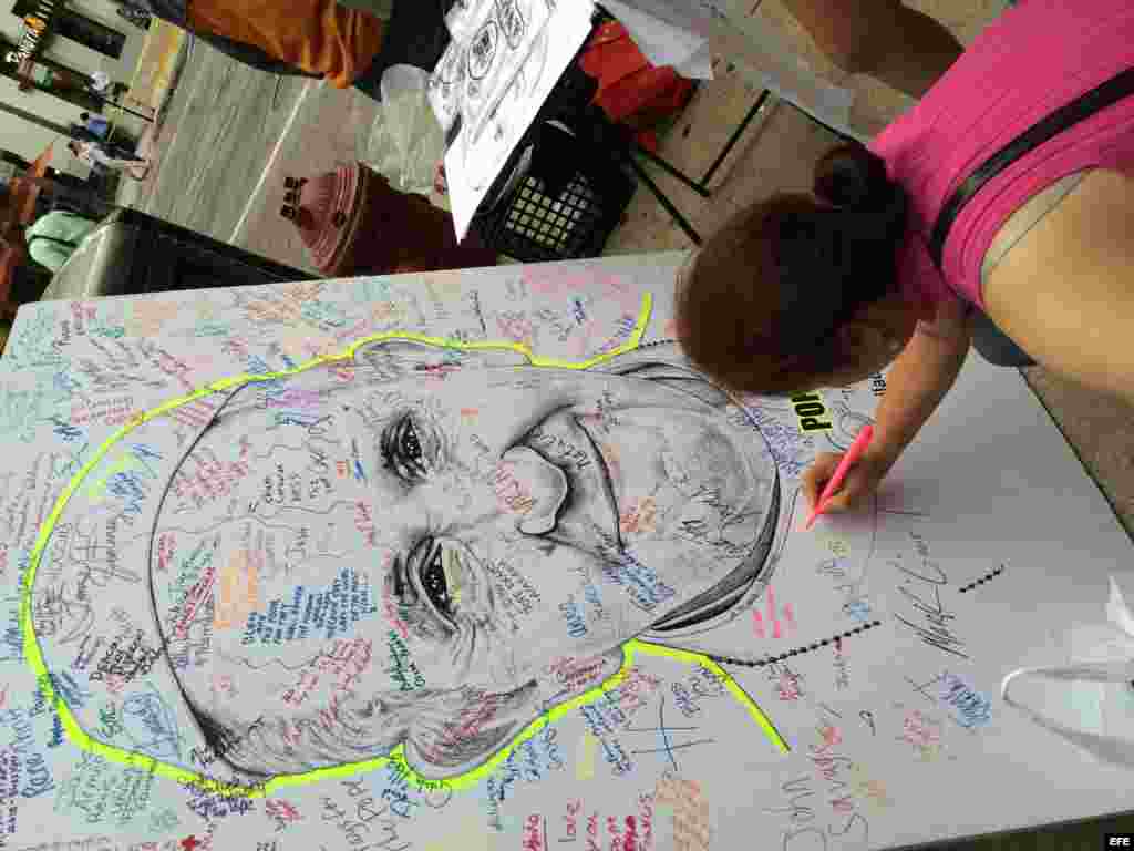 Una mujer firma sobre una imagen del papa Francisco en Filadelfia.