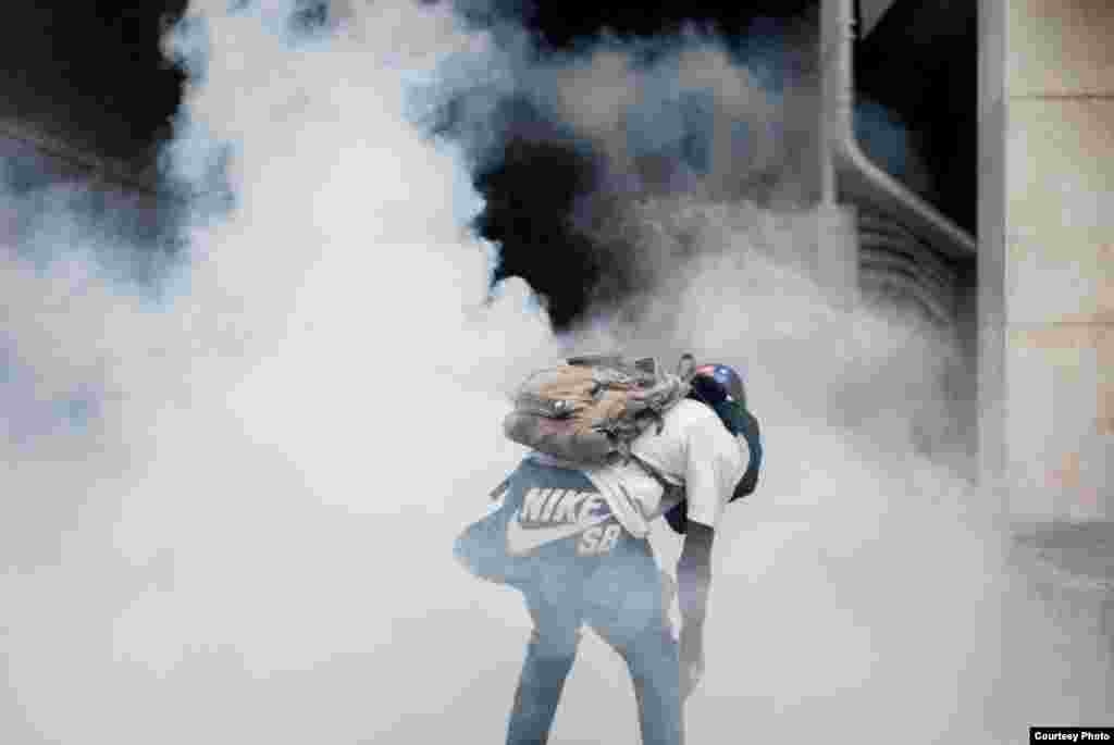 Manifestante resiste en medio de una nube de gas lacrimógeno. (Foto: Juan Pablo Arraez)