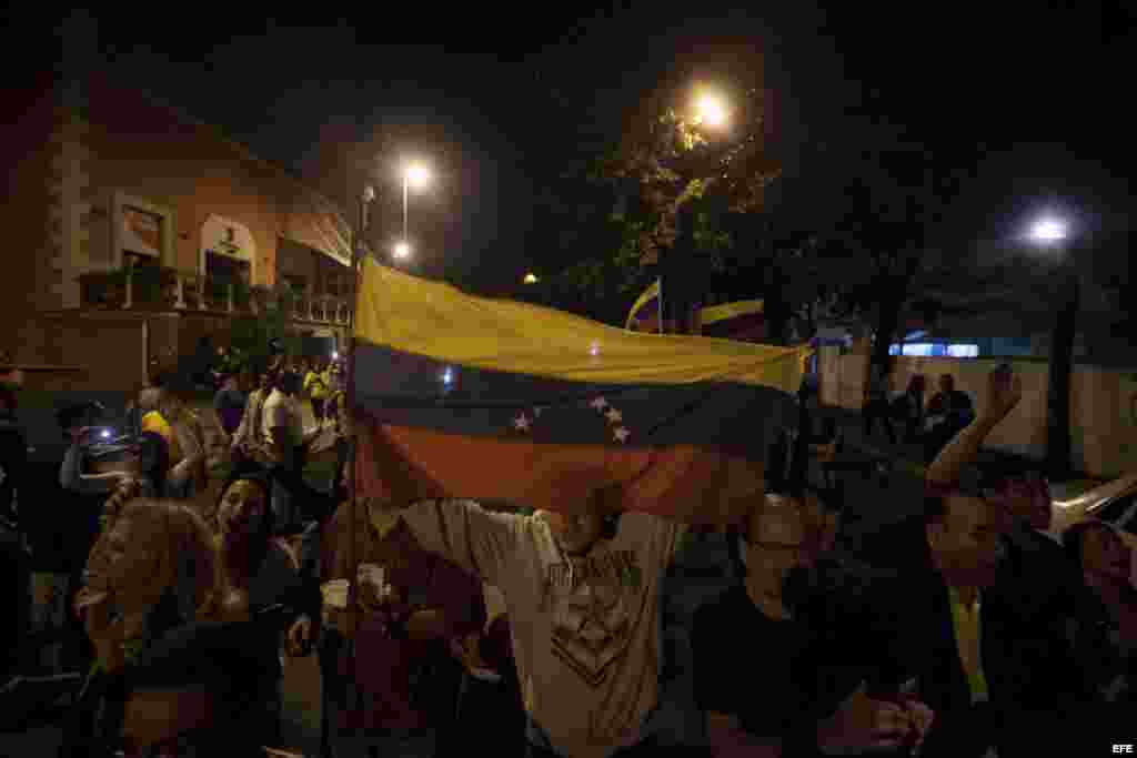 Varias personas celebran la victoria obtenida por la coalición opositora Mesa de Unidad Democrática (MUD), lunes 7 de diciembre de 2015, en la ciudad de Caracas (Venezuela).