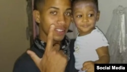 El joven Rowland de Jesús Castillo posa con su hijo.