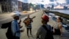 Cantantes cubanos cantan un bolero a una mujer en el malecón de La Habana, el 4 de diciembre de 2023. YAMIL LAGE / AFP