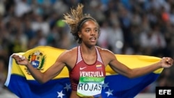 La atleta venezolana Yulimar Rojas celebra con la bandera de su país tras ganar la medalla de plata en el triple salto hoy, domingo 14 de agosto de 2016, durante los Juegos Olímpicos Rio 2016, en el estadio Olímpico de Rio de Janeiro (Brasil). EFE/FRANCK
