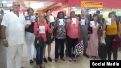Activistas regulados muestransus pasaportes con la negativa de viaje, en el Aeropuerto José Martí de La Habana.