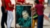 Un grupo de personas llevan un cuadro con la imagen de Fidel Catro hoy, viernes 2 de diciembre de 2016, mientras esperan la llegada de la caravana que traslada las cenizas del fallecido líder de la revolución cubana Fidel Castro, en Holguín, a 800km de L