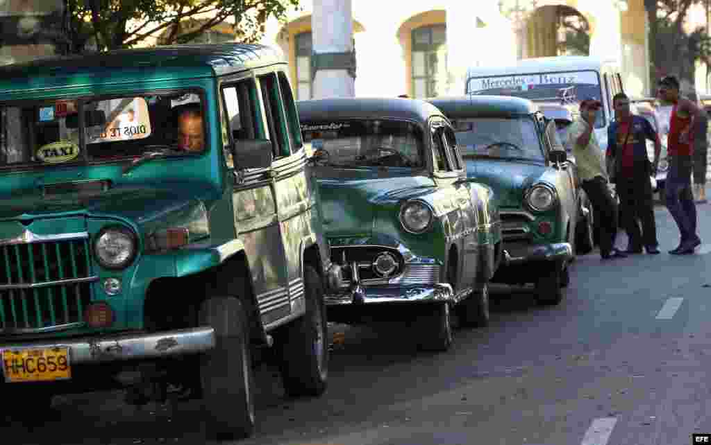 Varios taxistas conversando junto a sus autos a la espera de clientes en La Habana (Cuba).
