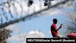 Un migrante pasa el tiempo en el campamento de Matamoros. REUTERS/Daniel Becerril.