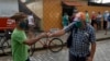 El saludo de dos cubanos en una calle de La Habana en vísperas del Día de los Pades (Yamil Lage/AFP).