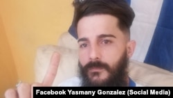 Preso político Yasmany González junto a la bandera cubana.