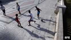 Jóvenes jugando fútbol en un parque en La Habana.