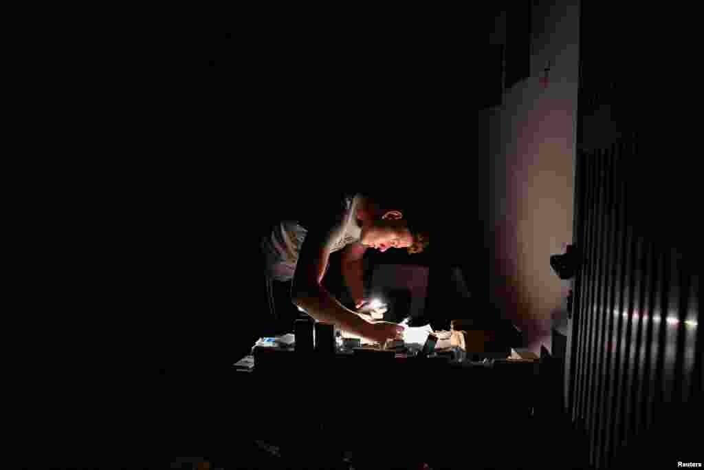 Una persona en Bejucal, Mayabeque se alumbra con un celular durante un apagón. 