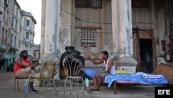 Dos hombres cuyas viviendas fueron severamente afectadas por el huracán Irma conversan junto a sus pertenencias, el jueves 21 de septiembre de 2017, en el malecón de La Habana (Cuba).