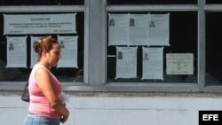 Una mujer camina junto a carteles alusivos a las elecciones municipales en Cuba. (Archivo)