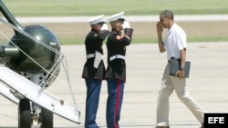 Barack Obama (d) saluda a la tripulación del helicoptero presidencial Marine 1 antes de partir a Camp David.