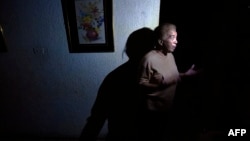 Una mujer habla en su casa ubicada en Maracaibo durante un corte de luz .