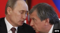 El presidente de Rosneft, la mayor petrolera de Rusia, Ígor Sechin (d), habla con el presidente ruso, Vladimir Putin.