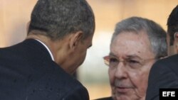 El presidente estadounidense Barack Obama (i), saluda al general cubano Raúl Castro, en Sudáfrica durante los funerales de Nelson Mandela.