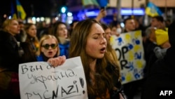 Una mujer sostiene un cartel que dice "Fuera de Ucrania, nazis rusos" durante una manifestación para apoyar a Ucrania.