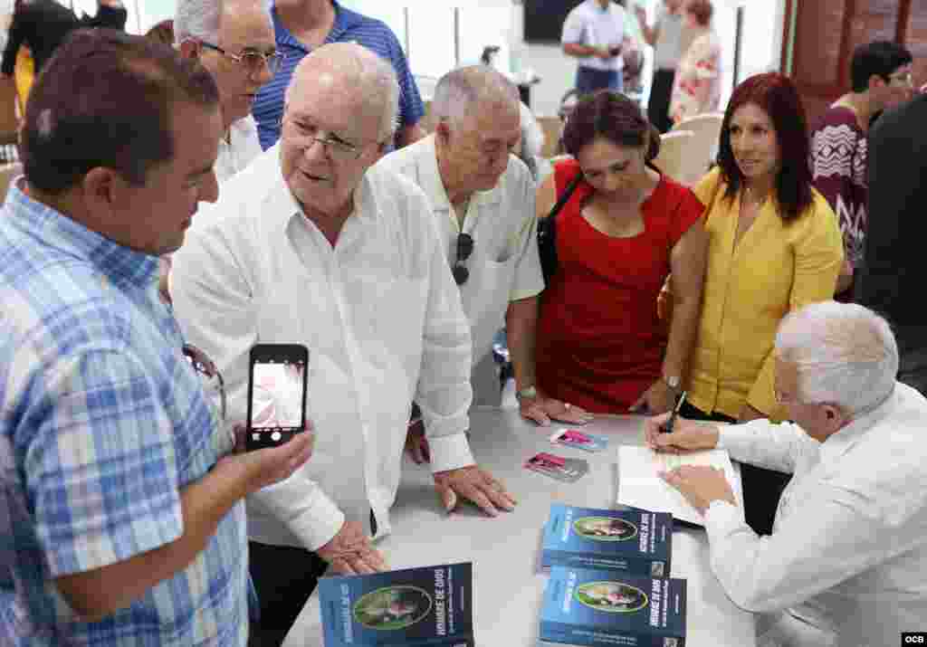 Julio Estorino firma su libro “Biografía de un hombre de Dios" sobre la vida de Monseñor Agustín Román. Foto OCB/ Roberto Koltun.