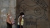 Dos mujeres caminan el martes por una calle de La Habana usando máscaras para evitar la propagación del coronavirus (Foto: Yamil Lage/AFP).