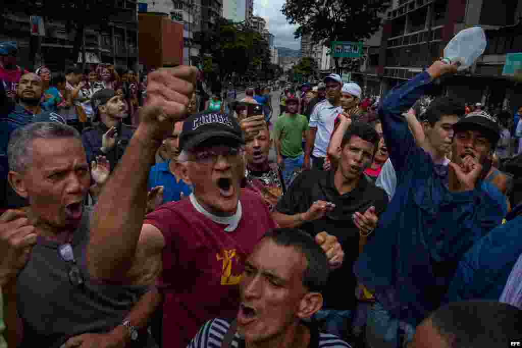 Un grupo de personas manifiestan contra miembros de la Guardia Nacional Bolivariana (GNB) hoy, jueves 2 de junio del 2016, en el centro de la ciudad de Caracas (Venezuela). La angustia por las varias horas de espera en filas interminables y el temor de n