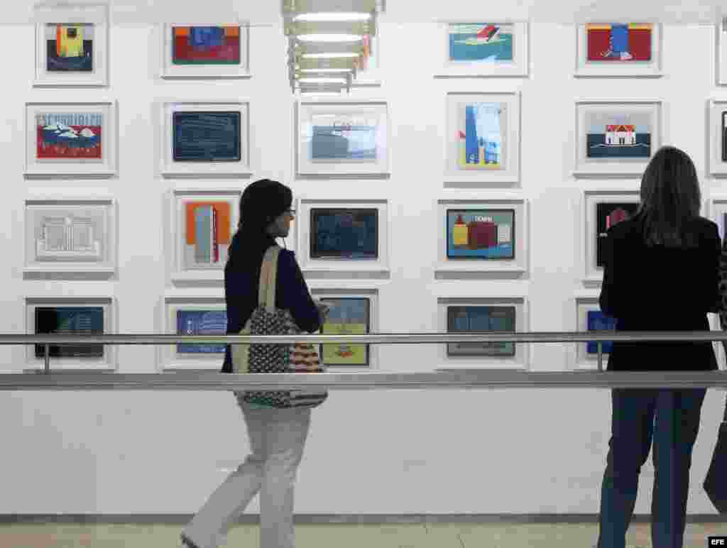 Dos visitantes obsrvan varias obras del artista cubano Carlos Garaicoa, que forman parte de la exposición "Orden aparente (poético-político)", una muestra comisariada por Vicente Todolí que recoge piezas únicas del autor que se exhiben en la Fundación Botín.