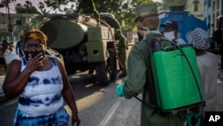 Un soldado de las fuerzas armadas usa una máscara como protección mientras limpia una calle con solución de cloro en La Habana. . (AP/Ramon Espinosa)