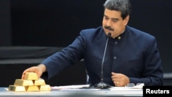 Nicolás Maduro toca una barra de oro mientras se dirige a los ministros responsables del sector económico en el Palacio de Miraflores.