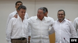 El presidente de Colombia, Juan Manuel Santos, el máximo líder de las FARC, Rodrigo Londoño, alias "Timochenko", y el presidente de Cuba, Raúl Castro, participan en el acto para presentar un acuerdo en los diálogos de paz en La Habana (Cuba).