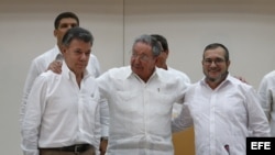 El presidente de Colombia, Juan Manuel Santos, el máximo líder de las FARC, Rodrigo Londoño, alias "Timochenko", y el presidente de Cuba, Raúl Castro, participan en el acto para presentar un acuerdo en los diálogos de paz en La Habana (Cuba).