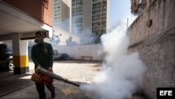 Un empleado de la Alcaldía de Chacao, en Caracas, fumiga un estacionamiento como medida preventiva contra el Zika.