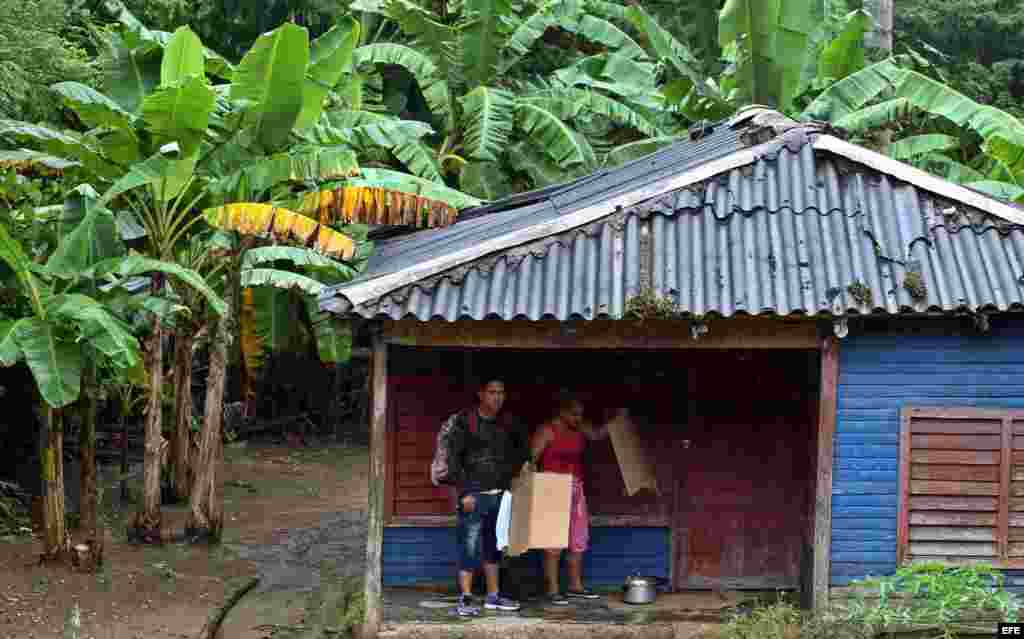 Dos personas se protegen de la lluvia hoy, martes 04 de octubre, en la ciudad de Baracoa, en Guantánamo.