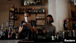 Diana Figueroa prepara tragos para llevar en su restaurante en La Habana.