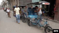 Varios bicitaxistas esperan clientes en una calle en La Habana.